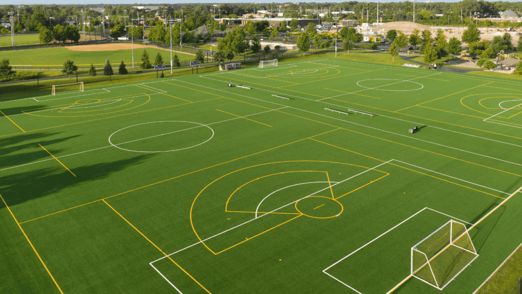 Aerial view of a multi purpose turf field with various markings for different sports and benches