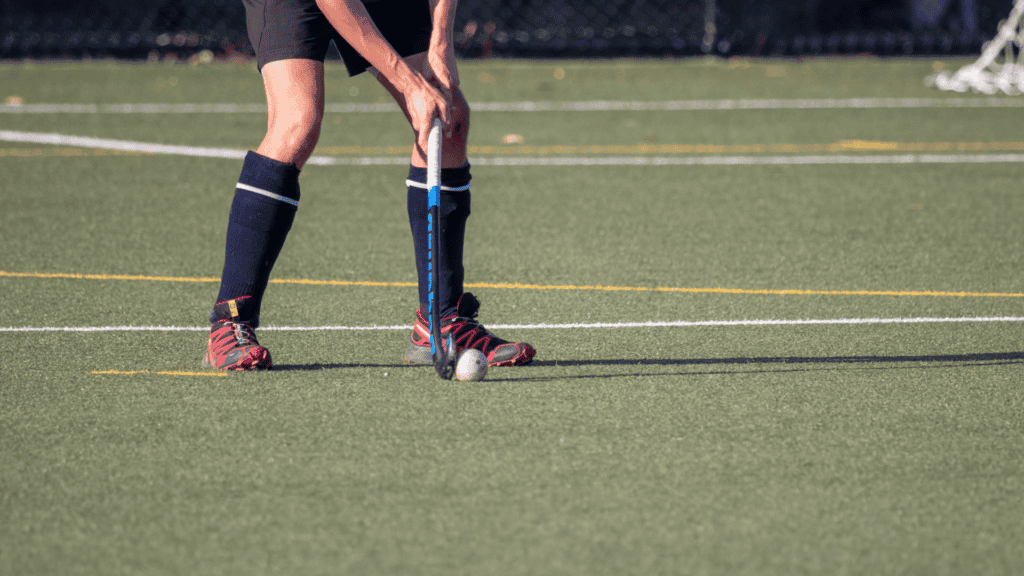 Field hockey player preparing to strike the ball on a turf field