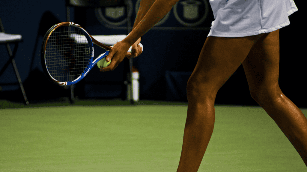 Tennis player serving the ball on a green tennis court