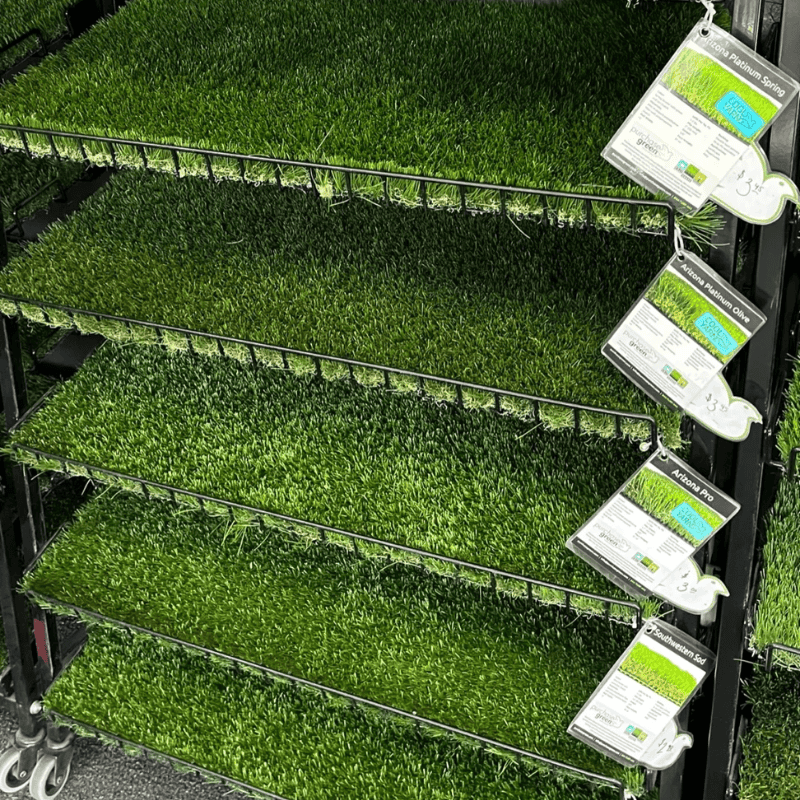 artificial grass rolls displayed in a store with different turf types for landscaping low maintenance synthetic grass versatile options