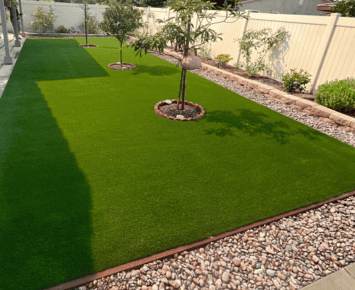 Commercial 12 commercial artificial grass installed on dirt with decorative stone borders and landscaping elements for a clean and vibrant outdoor area