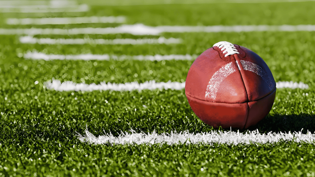 football on synthetic turf field with yard lines