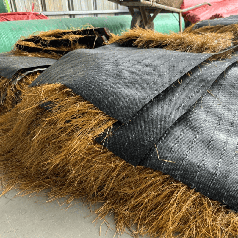 synthetic-thatch-roof-panels-stacked-on-concrete-floor-ready-for-installation