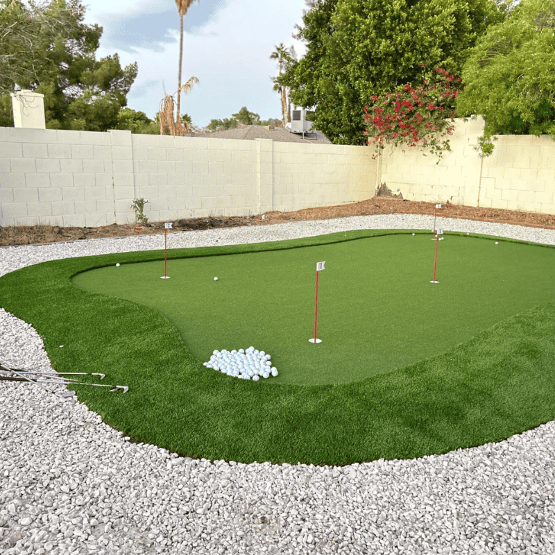Outdoor 13 synthetic turf putting green in residential yard with multiple holes and golf balls for recreational use