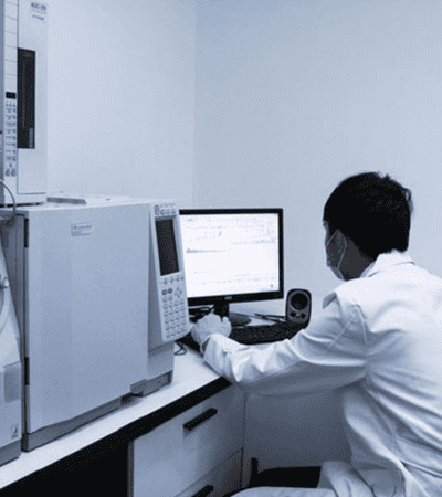 Somos líderes mundiales en soluciones de césped artificial 48 Técnico de laboratorio analizando materiales de césped artificial con equipo de prueba.