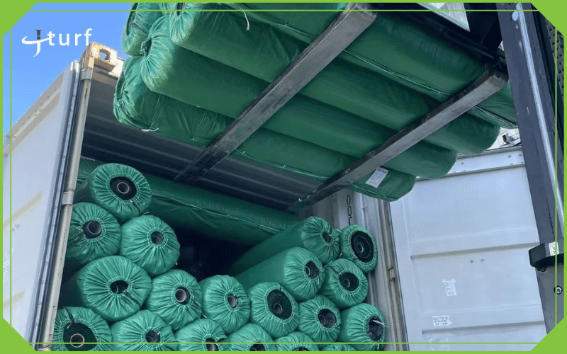 Rollos de césped artificial embalados dentro de un contenedor de envío para entrega de exportación.