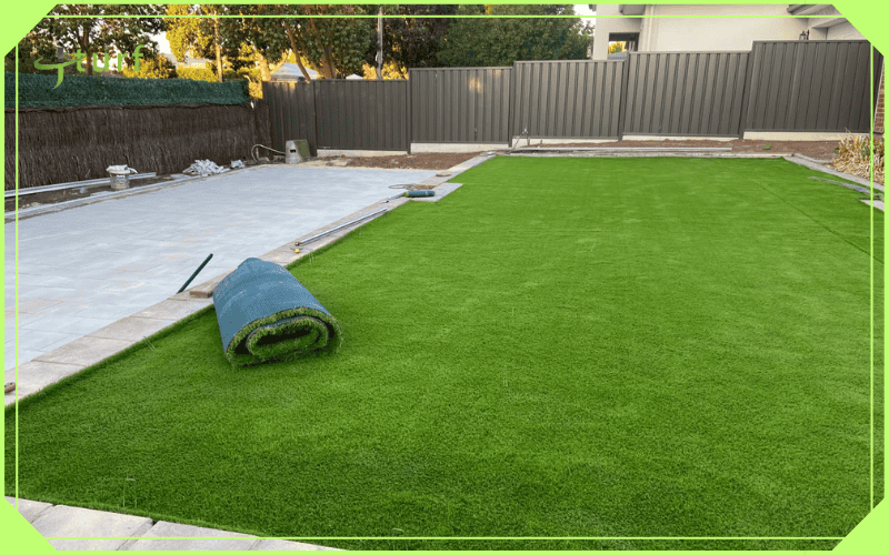 Artificial turf partially installed in residential backyard yard with concrete patio