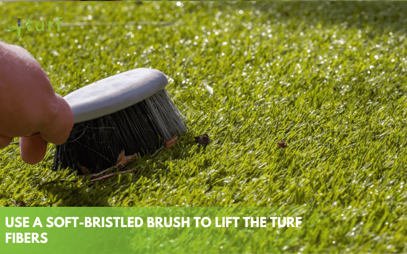 Brushing artificial grass with a soft bristled brush to lift turf fibers