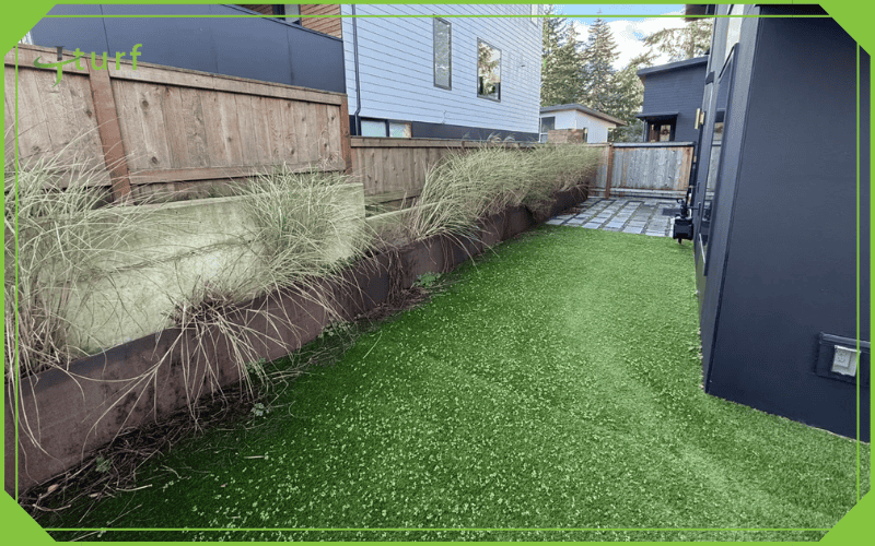Synthetic grass with patches of weeds emerging from the artificial turf
