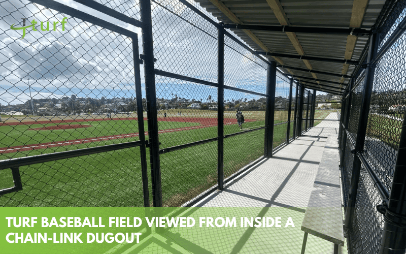 A Clear Look at the Cost to Build a Turf Baseball Field 3 urf baseball field viewed through chain link dugout with players in the distance