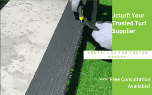 worker using a tool to smooth synthetic grass installation