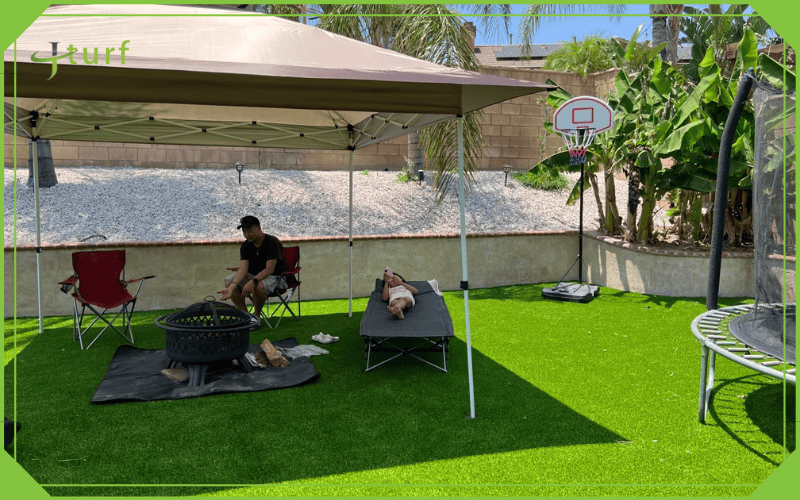 family lounging under canopy on artificial grass backyard