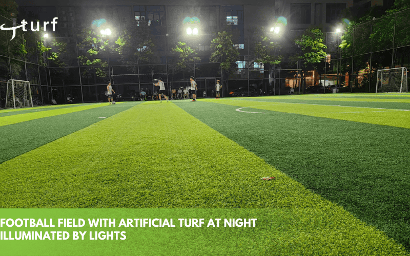 football field with artificial turf at night illuminated by lights