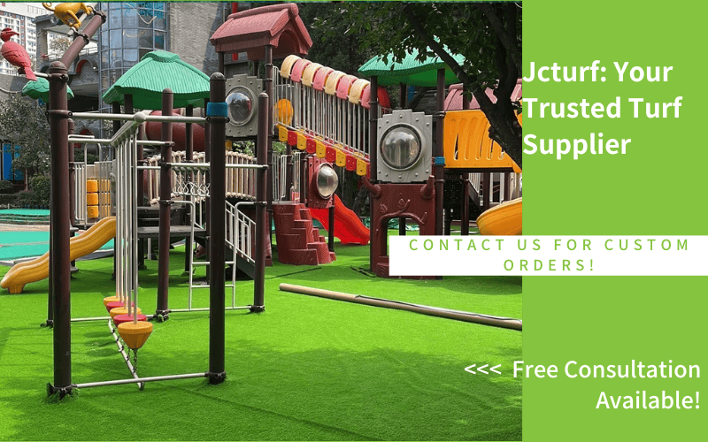 A colorful playground with slides, climbing structures, and swings on a grassy turf surface, under a clear sky.