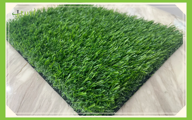 A close-up of a patch of artificial grass resting on a light-colored surface.